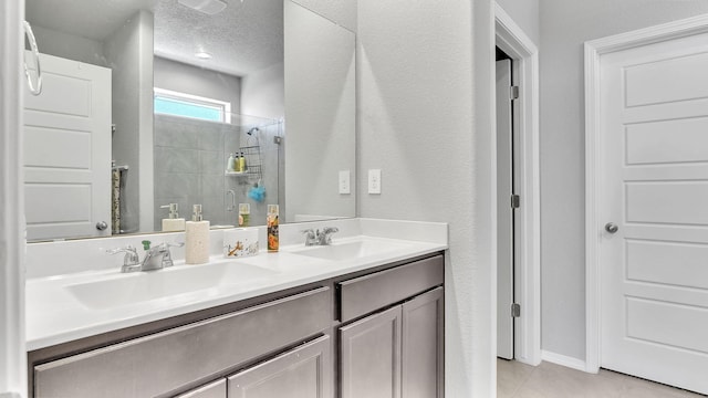 889 Tazanita Loop SE, Rio Rancho, NM 87124 - full bathroom featuring a tile shower, tile patterned floors, double vanity, and a textured ceiling