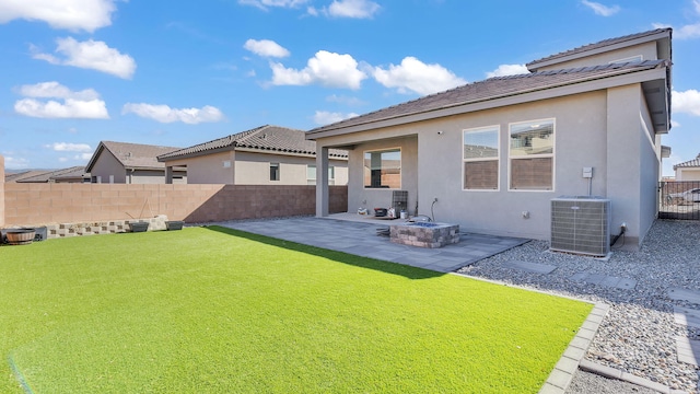 rear view of house featuring a fire pit, central AC unit, stucco siding, a fenced backyard, and a patio