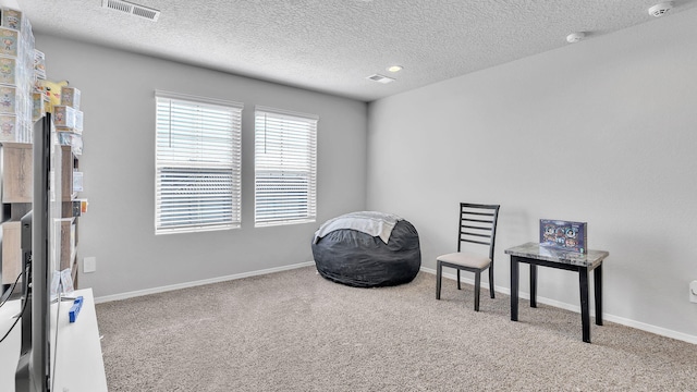 sitting room featuring visible vents, a textured ceiling, baseboards, and carpet