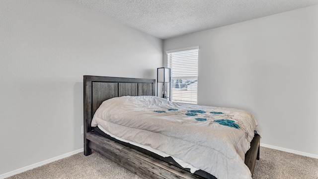 carpeted bedroom with baseboards and a textured ceiling