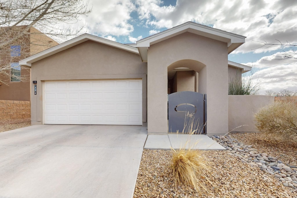 view of front of property with a garage, driveway, and stucco siding