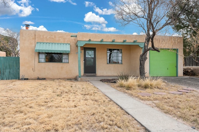 southwest-style home with fence and stucco siding