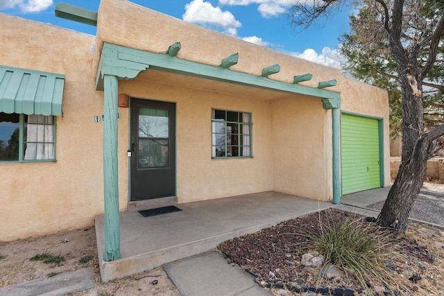 doorway to property featuring a patio area and stucco siding