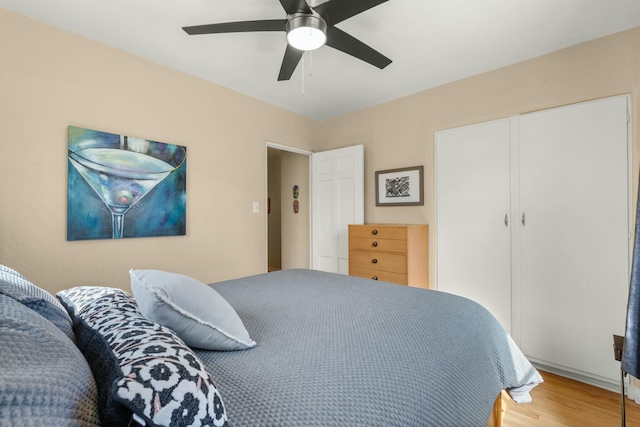 bedroom featuring ceiling fan, a closet, and wood finished floors