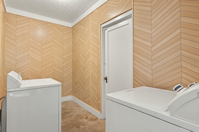 clothes washing area with laundry area, a textured ceiling, and independent washer and dryer