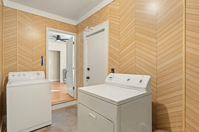 clothes washing area with laundry area, washing machine and dryer, and a textured ceiling