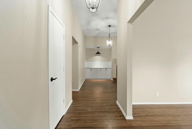 corridor featuring wood finished floors and baseboards