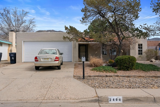 view of front of property with a tile roof, driveway, an attached garage, and stucco siding