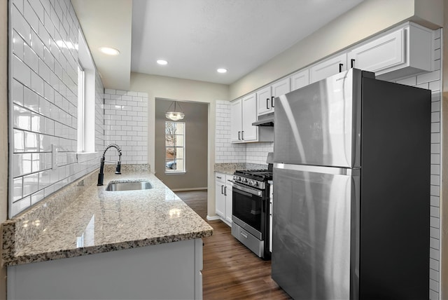 kitchen featuring stainless steel appliances, dark wood-type flooring, backsplash, and a sink