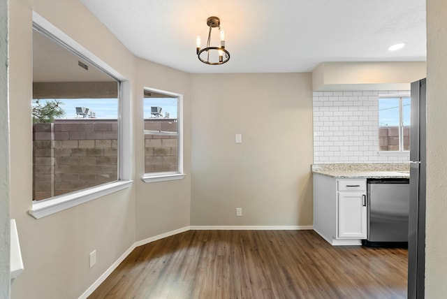 kitchen with white cabinetry, baseboards, fridge, backsplash, and dark wood finished floors