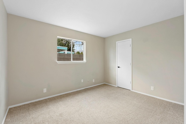 carpeted spare room with baseboards