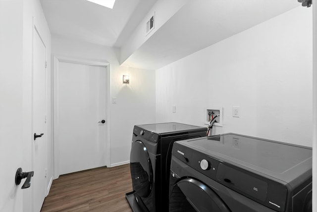 laundry area featuring wood finished floors, visible vents, and separate washer and dryer