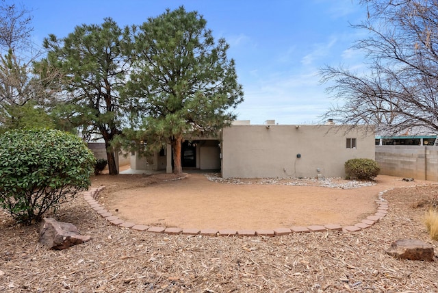 rear view of property with fence and stucco siding