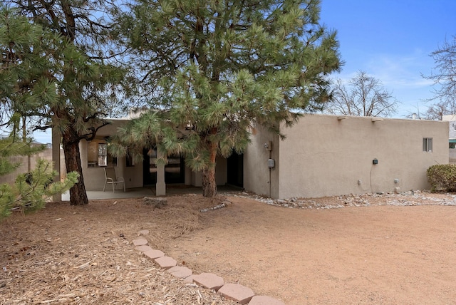 rear view of house with a patio area and stucco siding