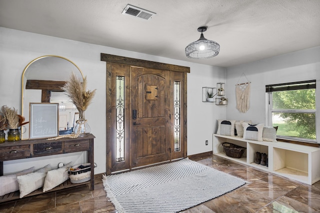 foyer featuring visible vents, baseboards, a textured ceiling, and marble finish floor