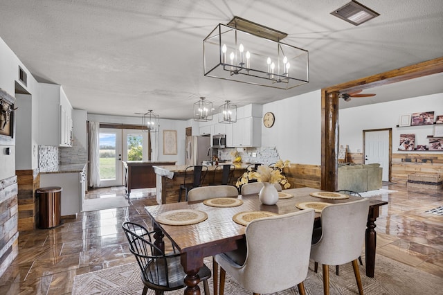 dining room with visible vents, marble finish floor, a textured ceiling, and an inviting chandelier