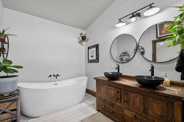 bathroom with double vanity, a soaking tub, and a sink