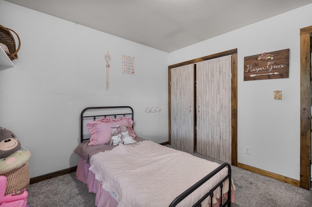 carpeted bedroom with a closet and baseboards