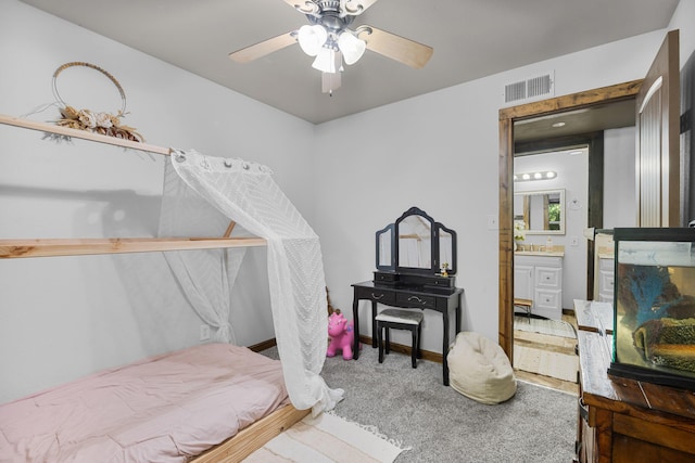 bedroom with visible vents, ensuite bathroom, carpet flooring, baseboards, and ceiling fan