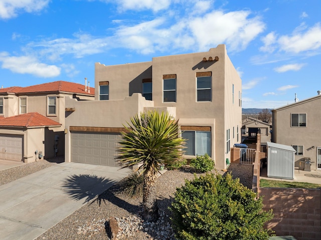 pueblo-style house with stucco siding and driveway