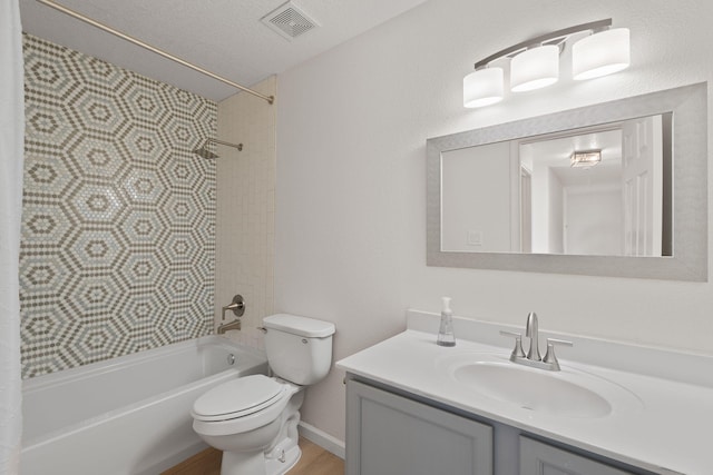 full bathroom with vanity, shower / bath combination, visible vents, a textured ceiling, and toilet