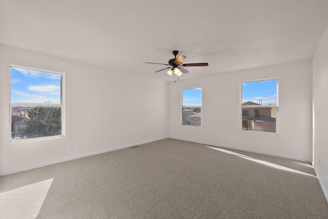 spare room with baseboards, a textured ceiling, carpet, and a ceiling fan