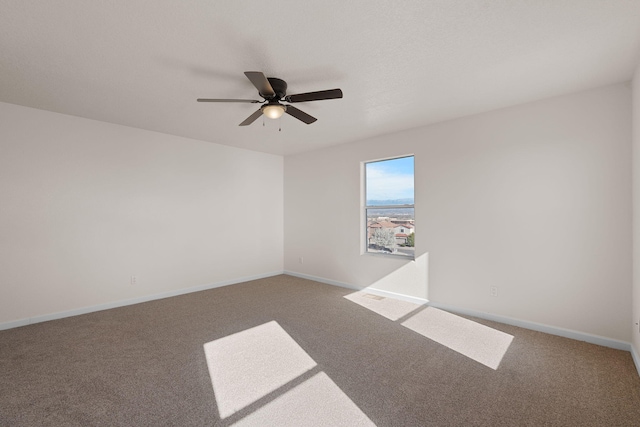 unfurnished room with ceiling fan, baseboards, and carpet