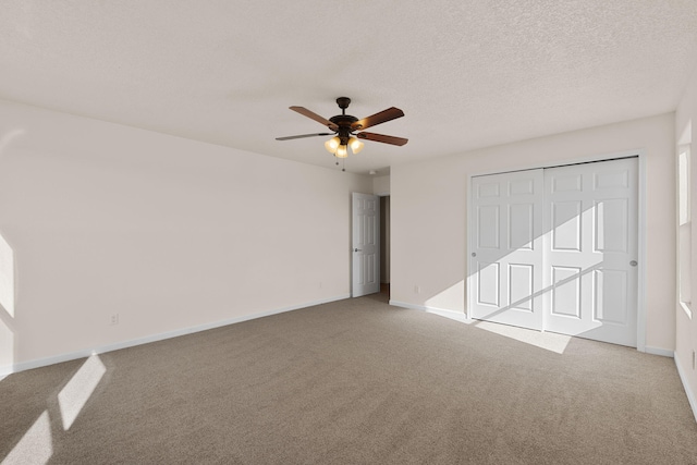 unfurnished bedroom with a textured ceiling, baseboards, and carpet floors