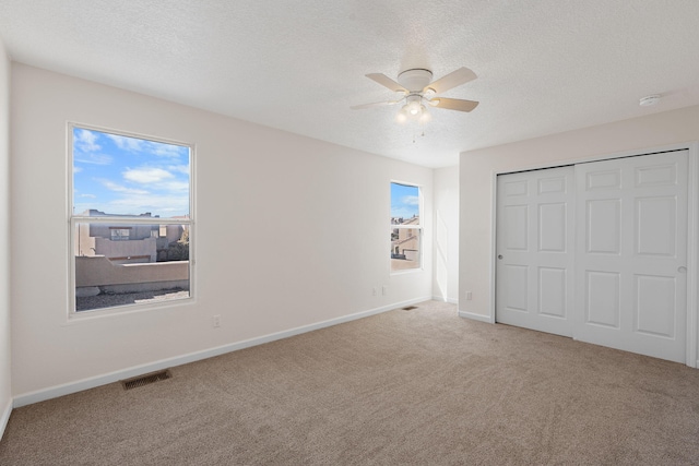 unfurnished bedroom featuring a ceiling fan, baseboards, carpet floors, and a textured ceiling