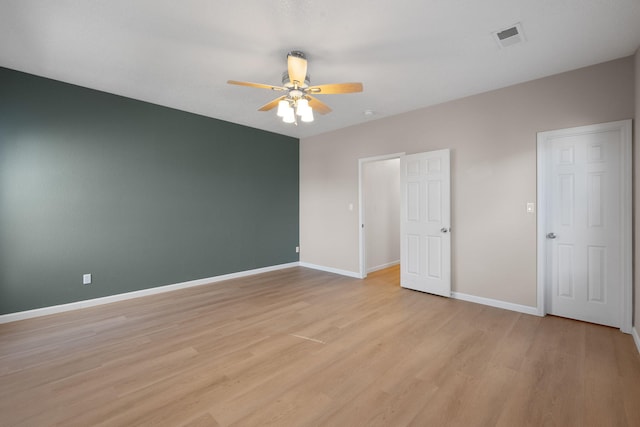 unfurnished bedroom featuring baseboards, visible vents, light wood finished floors, and ceiling fan