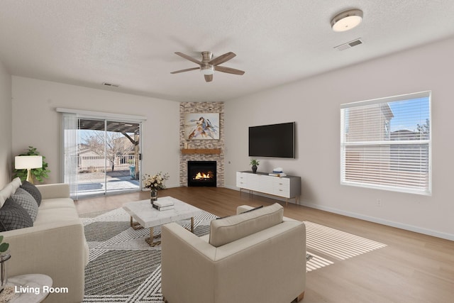 8104 Sleeping Bear Dr NW, Albuquerque, NM 87120 - living area with ceiling fan, wood finished floors, a textured ceiling, and a fireplace