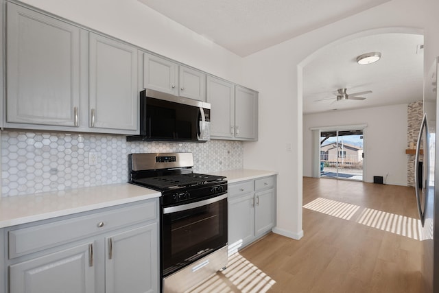 kitchen with decorative backsplash, light countertops, appliances with stainless steel finishes, and gray cabinetry