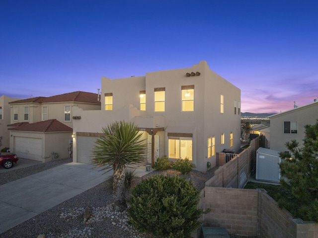 view of front of property featuring fence, central AC, stucco siding, concrete driveway, and a garage