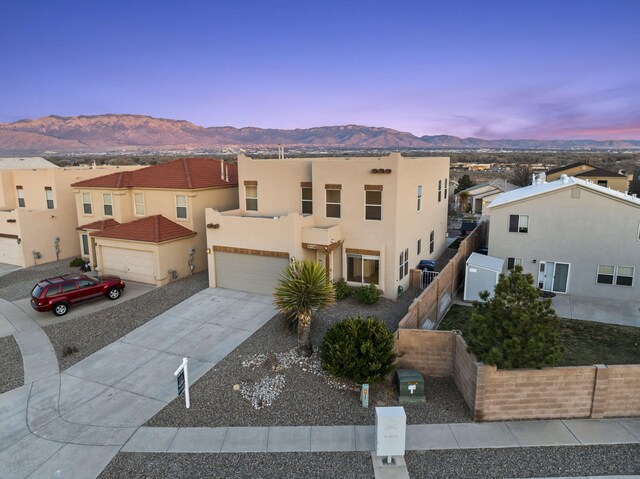 view of front facade with concrete driveway, a mountain view, a residential view, and stucco siding