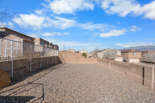 view of yard with a mountain view, a residential view, and a fenced backyard