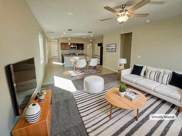 living area featuring a textured ceiling, baseboards, a ceiling fan, and recessed lighting