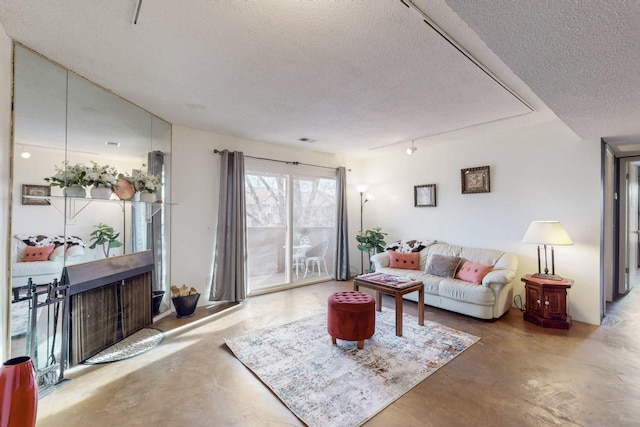 living area with concrete flooring, visible vents, and a textured ceiling