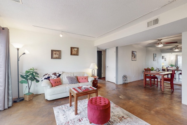 living area featuring a ceiling fan, concrete floors, visible vents, and a textured ceiling