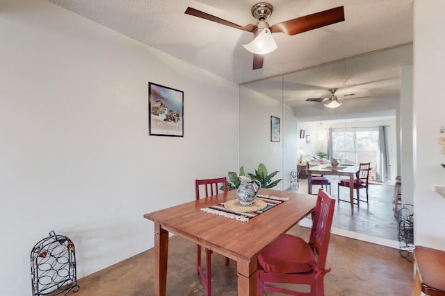 dining area with concrete flooring, a textured ceiling, and a ceiling fan