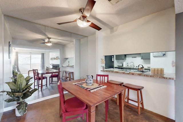 dining room featuring a textured ceiling, ceiling fan, concrete floors, and visible vents