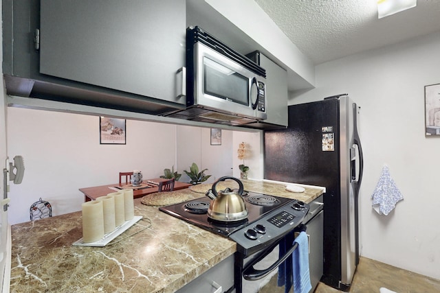 kitchen with stainless steel appliances, a textured ceiling, and tile countertops