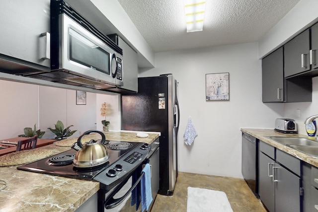 kitchen with a textured ceiling, gray cabinetry, a sink, light countertops, and black appliances