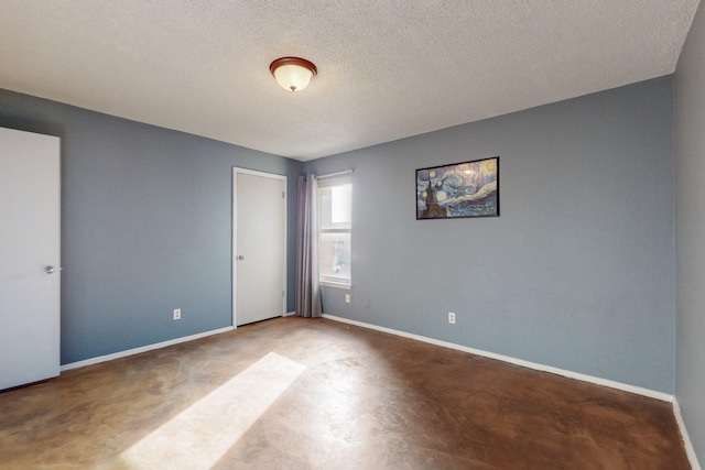 empty room with baseboards and a textured ceiling