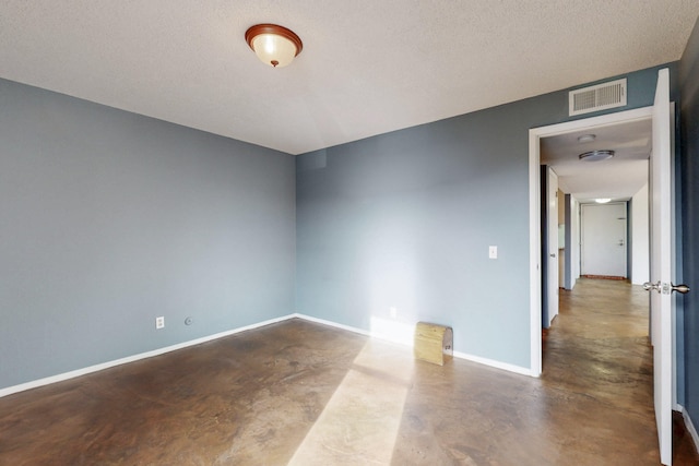 unfurnished room featuring baseboards, a textured ceiling, visible vents, and concrete flooring