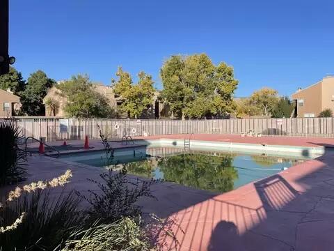 pool with a patio area and fence