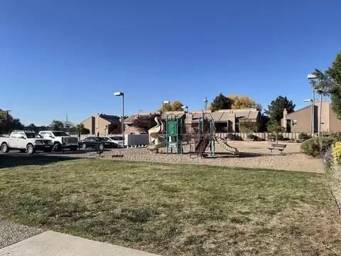 exterior space with a residential view, a lawn, and playground community