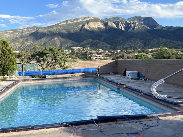 view of swimming pool featuring a fenced in pool, a fenced backyard, and a mountain view