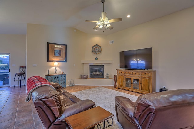 living room with visible vents, a ceiling fan, a glass covered fireplace, tile patterned floors, and vaulted ceiling