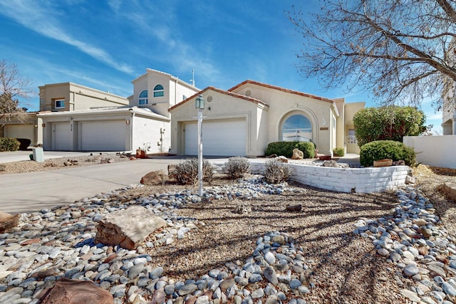 view of front facade featuring a garage, concrete driveway, and stucco siding