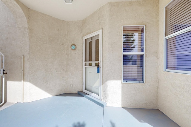 view of exterior entry featuring a patio and stucco siding